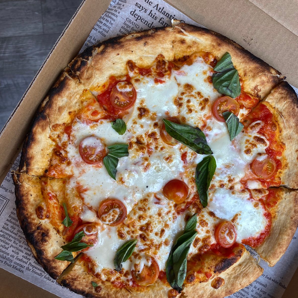 A wood-fired margherita pizza from The Village Hearth, fresh out of the oven
